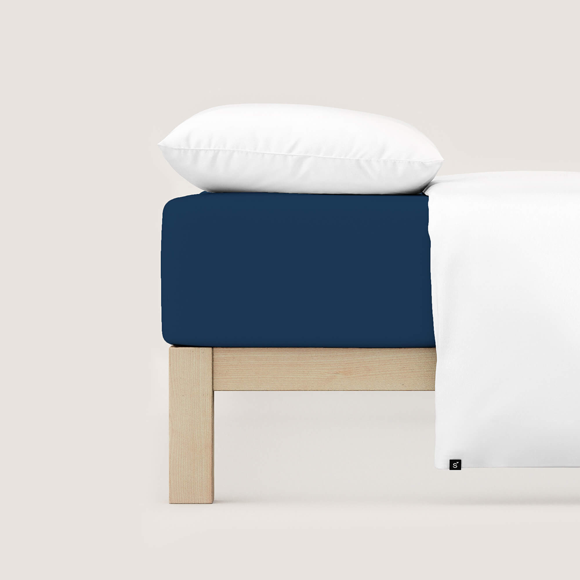 Spannbettlaken Casual von Schlafgut in Farbe blue deep aus 100% Bio-Baumwolle auf Bett mit Kissen und Decke
