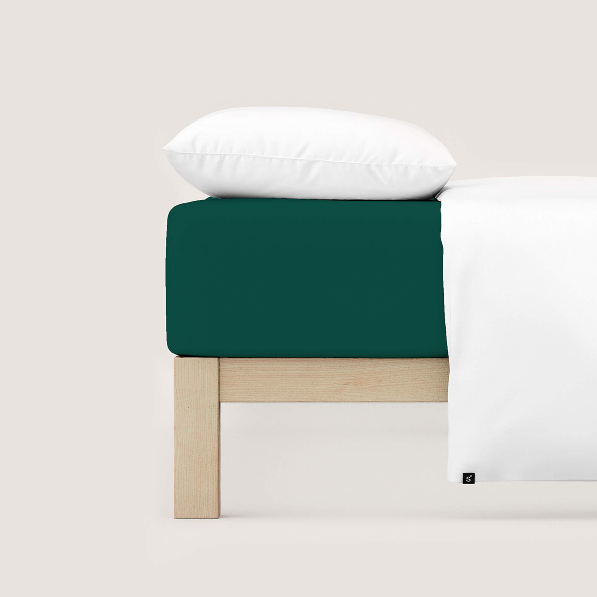 Spannbettlaken Casual von Schlafgut in Farbe green deep aus 100% Bio-Baumwolle auf Bett mit Kissen und Decke
