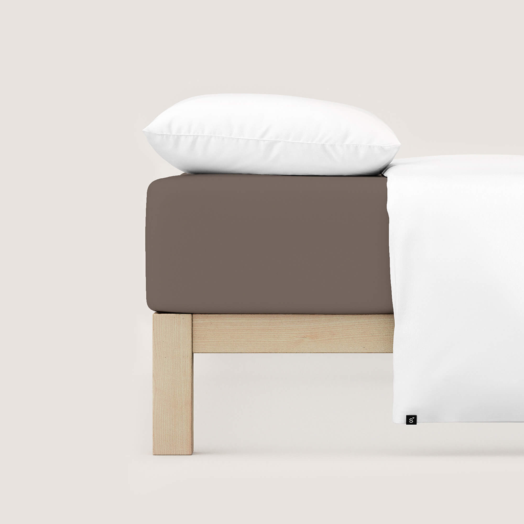 Spannbettlaken Casual von Schlafgut in Farbe sand deep aus 100% Bio-Baumwolle auf Bett mit Kissen und Decke