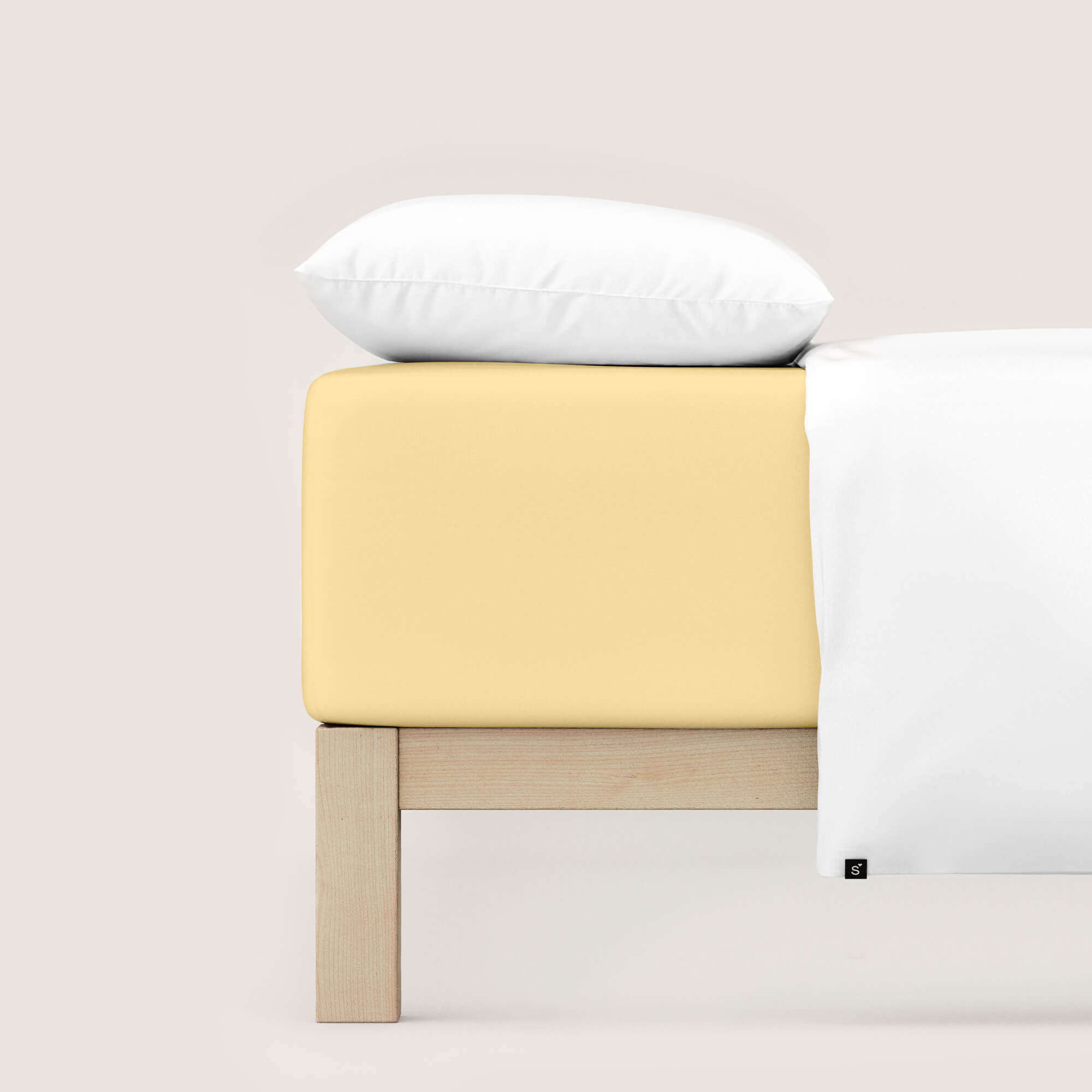 Spannbettlaken Pure Boxspring von Schlafgut in Farbe yellow mid aus 95% Bio-Baumwolle und 5% Elasthan auf Bett mit Kissen und Decke