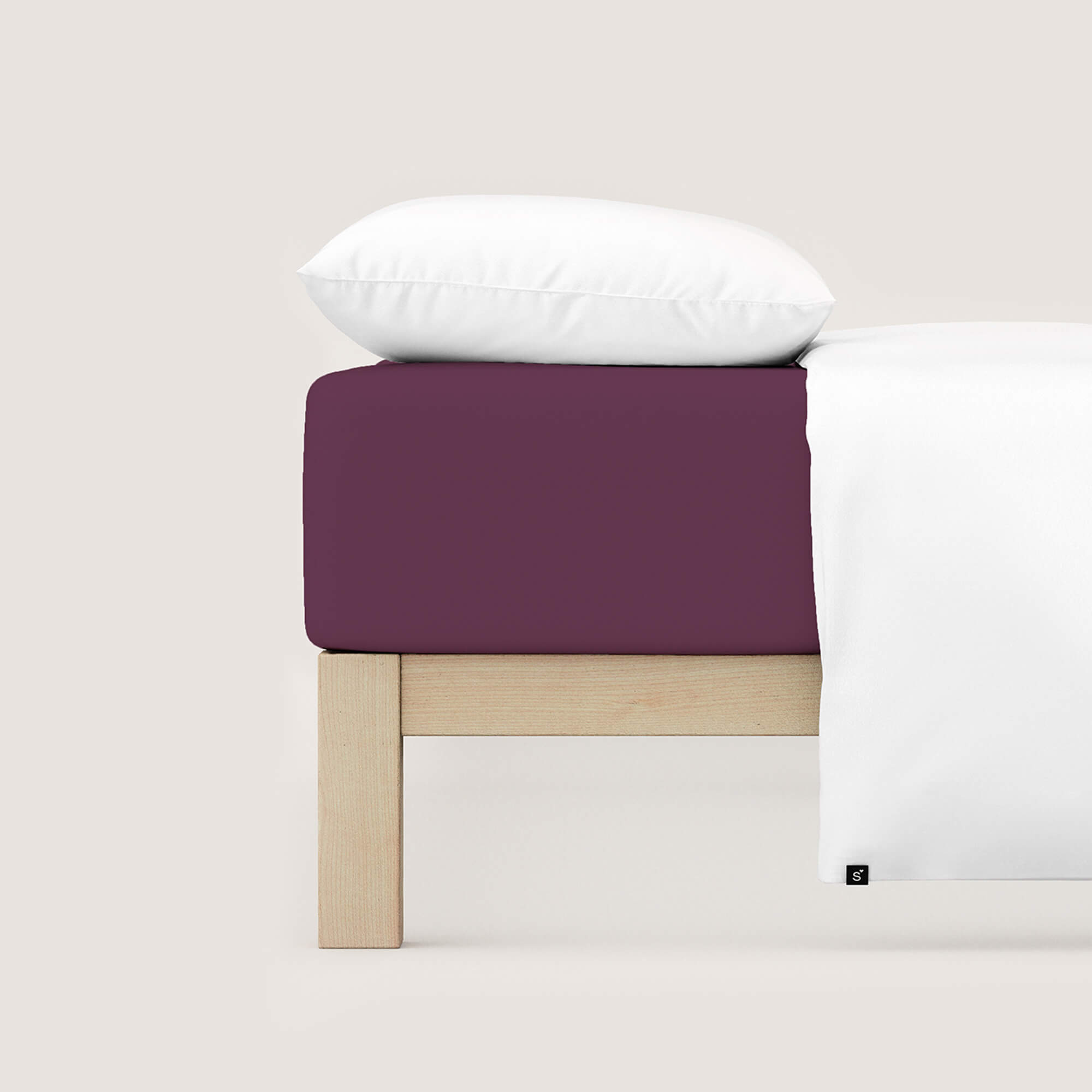 Spannbettlaken Casual von Schlafgut in Farbe purple deep aus 100% Bio-Baumwolle auf Bett mit Kissen und Decke