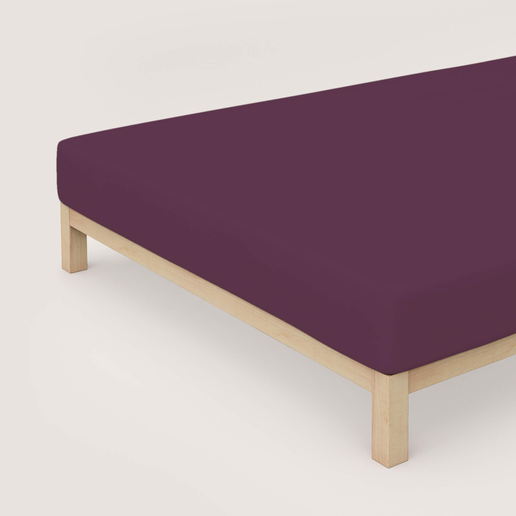 Spannbettlaken Pure von Schlafgut in Farbe purple deep aus 95% Bio-Baumwolle und 5% Elasthan auf Bett in Vogelperspektive