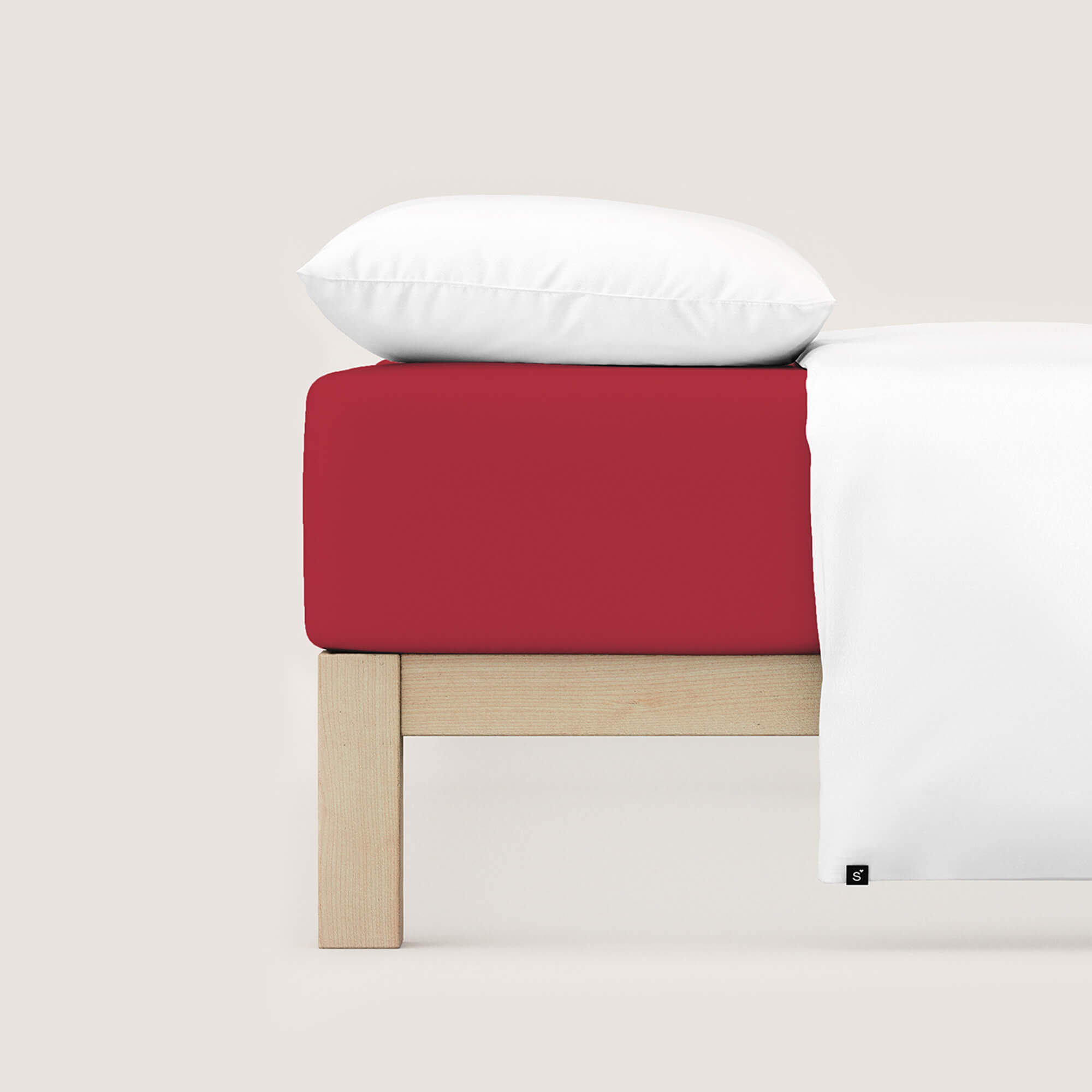 Spannbettlaken Casual von Schlafgut in Farbe red deep aus 100% Bio-Baumwolle auf Bett mit Kissen und Decke